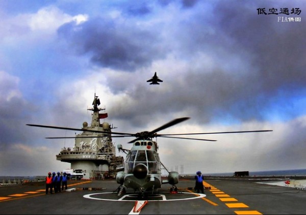Um caça chinês da Marinha, Shenyang J-15  sobrevoa um helicóptero  Z8 a bordo do 'Liaoning'