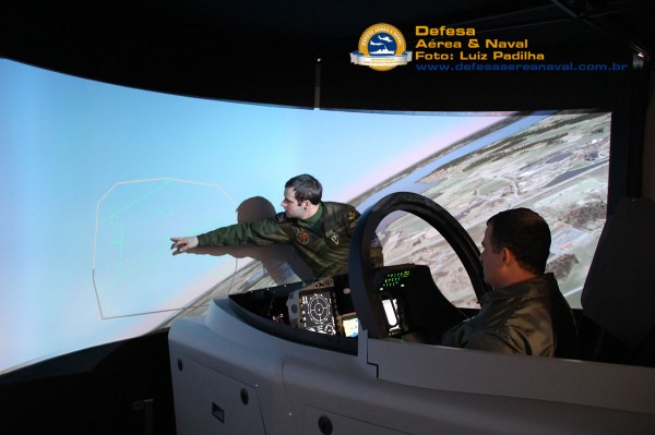 Piloto sueco Jakob Högberg passa informações sobre o Gripen no simulador