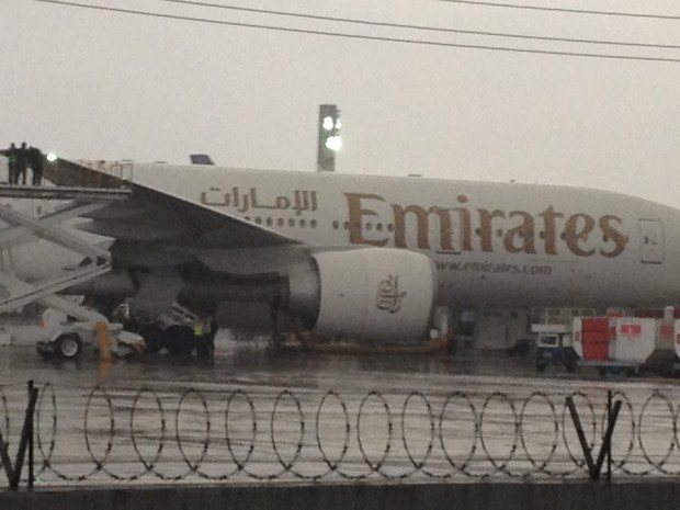 Funcionários da Emirates verificam o problema na asa atingida (Foto: Gabriel Barreira G1)