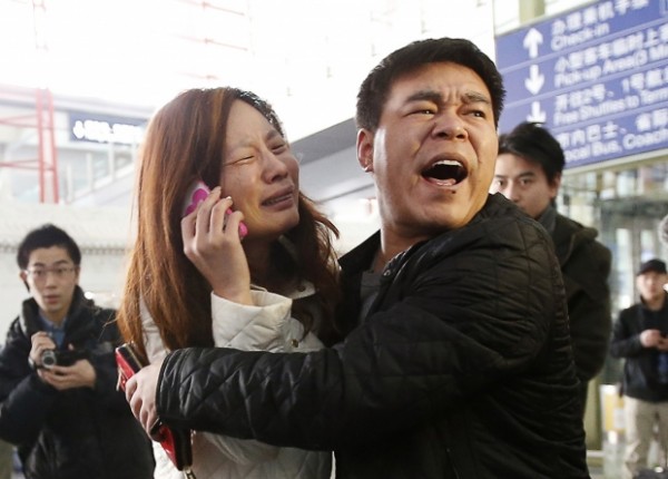 Uma parente de um dos passageiros a bordo do voo MH370 da Malaysia Airlines chora enquanto fala no telefone no Aeroporto Internacional de Pequim KIM KYUNG-HOON