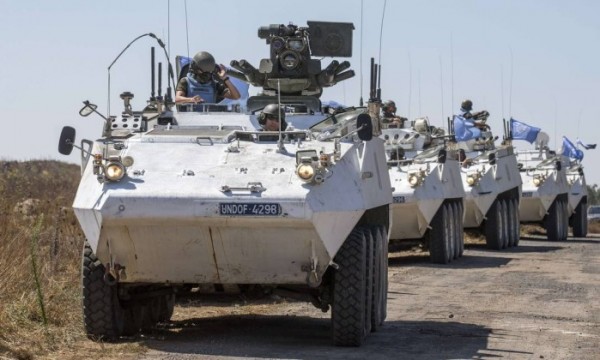 Membros da Força das Nações Unidas aguardam em seus veículos blindados nas Colinas de Golã enquanto eles esperam para cruzar para a Síria - JACK GUEZ / AFP