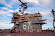 The tower of the USS John F. Kennedy aircraft carrier stands 19 stories above the water and would be a significant presence in Portland Harbor if a proposal to dock the ship at the city's new mega-berth is approved.