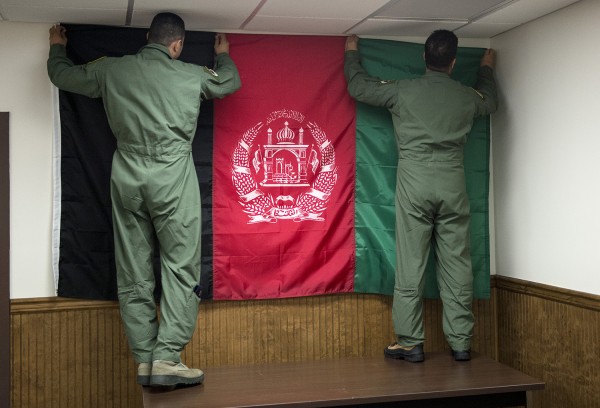 Alunos pilotos afegãos pendurar uma bandeira afegã na parede de sua sala de treinamento na 81st Esquadrão de Caça, Base Aérea de Moody, na Geórgia. Moody foi escolhido para sediar o treinamento por causa do espaço aéreo disponível, e de aeródromos e instalações adequadas.