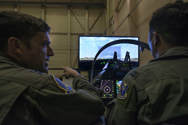 Um piloto instrutor da Força Aérea dos Estados Unidos designado para o 81o Esquadrão de Caça, Base Aérea de Moody, na Geórgia, analisa o voo depois de um aluno piloto afegão desembarcou no Super Tucano simulador de vôo A-29. Os alunos trabalham com seus instrutores norte-americanos para construir familiaridade e proficiência no simulador antes de voar para a A-29. O A-29 é uma aeronave de dois lugares, permitindo aos alunos a voar com pilotos instrutores norte-americanos no banco de trás. O piloto instrutor americana pode assumir o controle da aeronave a qualquer momento, mas os estudantes são esperados para voar a aeronave através de toda a missão.
