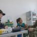 A 1º Tenente da Marinha do Brasil Lívia Laura (à esq.) e o Capitão de Fragata da Marinha dos EUA Edmund Milder (à dir.) examinam uma jovem paciente durante a visita à clínica médica Heraclio Emiliano Moda, em Axinim, Brasil - FOTO: 2º Sargento da Marinha dos EUA Byron C. Linder