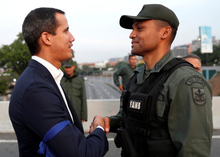 Juan Guaidó cumprimenta um militar perto de uma base aérea em Caracas — Foto: Carlos Garcia Rawlins/Reuters