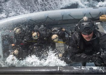 Membros do Grupo de Operações Táticas Naval a bordo do HMCS Halifax fazem rapel em um barco inflável de casco rígido de operações especiais como parte de exercícios de treinamento durante a Operação Reassurance 2019.