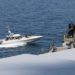 Uma foto da Marinha dos EUA mostra um barco com a bandeira iraniana ao lado de um navio dos EUA no Golfo Pérsico, em 15 de abril de 2020. US Navy