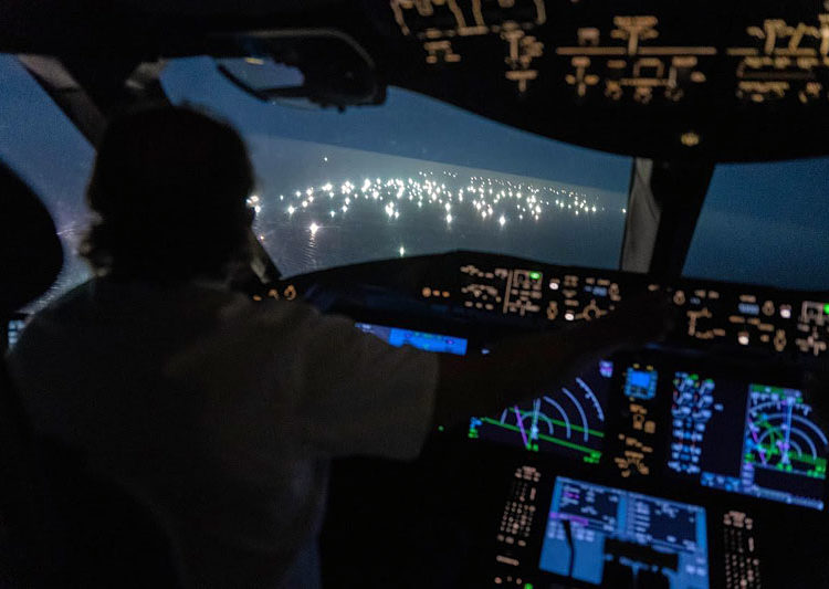 Imagem da cabine do Boeing 787 de Enrique Piñeyro, comandado por ele mesmo (de costas na foto). O que você vê através do vidro é a cidade dos barcos de pesca estrangeiros. (Foto: Franco Fafasuli)