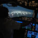 Imagem da cabine do Boeing 787 de Enrique Piñeyro, comandado por ele mesmo (de costas na foto). O que você vê através do vidro é a cidade dos barcos de pesca estrangeiros. (Foto: Franco Fafasuli)