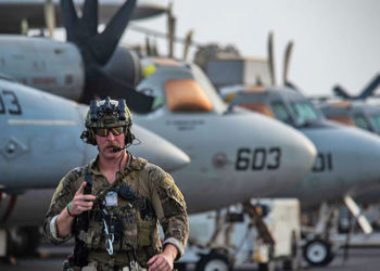 Especialista em explosivos da US Navy se prepara para embarcar no MH-60S SeaHawk do USS Ronald Reagan