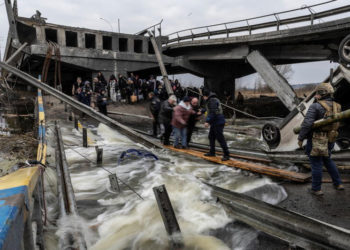 Moradores locais atravessam uma ponte destruída ao evacuarem da cidade de Irpin, perto de Kiev, Ucrânia, 7 de março de 2022 REUTERS/Carlos Barria
