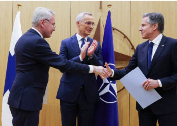 O Ministro das Relações Exteriores da Finlândia, Pekka Haavisto (L), cumprimenta o Secretário de Estado dos EUA, Antony Blinken, ladeado pelo Secretário-Geral da OTAN, Jens Stoltenberg (C), enquanto ele entrega a adesão da Finlândia aos documentos da OTAN.