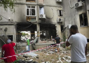 Israelitas inspecionam um edifício residencial danificado após ter sido atingido por um foguete disparado da Faixa de Gaza, em Ashkelon, Israel, segunda-feira, 9 de outubro de 2023. (Erik Marmor/AP)