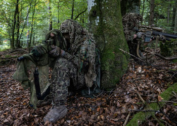 Latvian and German snipers conceal themselves with ghillie suits during the 2023 European Best Sniper Competition.