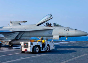 Caça F/A-18 Super Hornet e um trator reboque no convoo